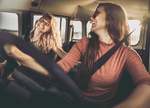 two young women in a car laughing