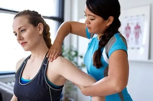 physical therapist assistant stretching a patient