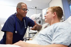 Male ER nurse talking with a patient in emergency room