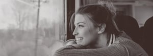 young woman on a train looking out the window