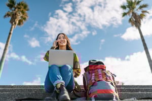backpacker sitting on phone with computer