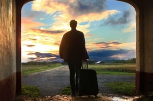 walking into sunset with suitcase