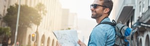 young man exploring a big city map in hand 