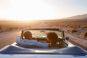 two people in a convertible car driving