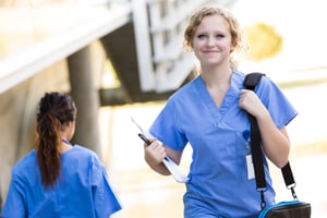 nurse walking outside with belongings