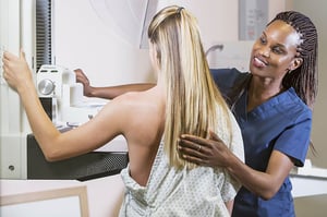 Mammo tech giving a patient a mammogram.
