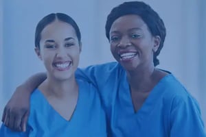 two smiling nurses with arms around each ohther