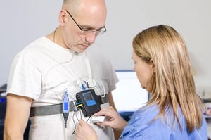 Sleep tech nurse applying a monitor to a patient.