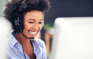 smiling recruiter with headset at a computer