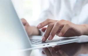 student typing on a laptop