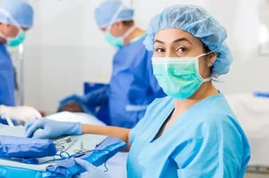 surg tech in an operating room setting up trays