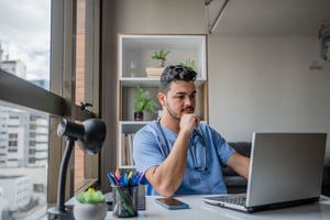 Young male nurse sitting at a laptop